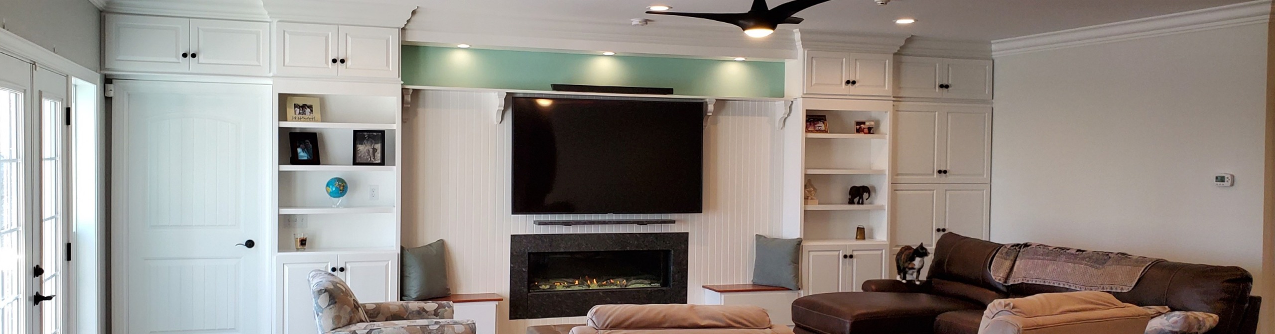 Expansive wall of built-in cabinets around a tv and fireplace center